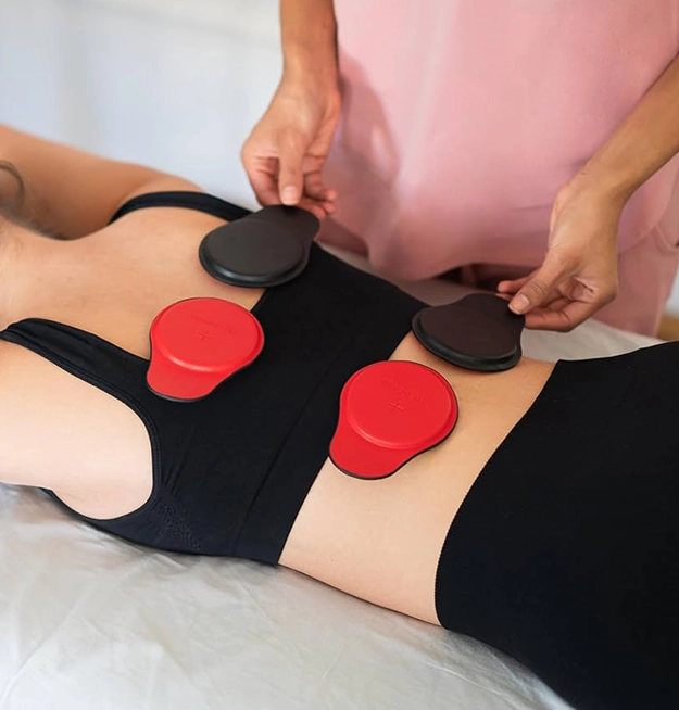 Person Receiving Magnetic Therapy with Red and Black Magnets on Back